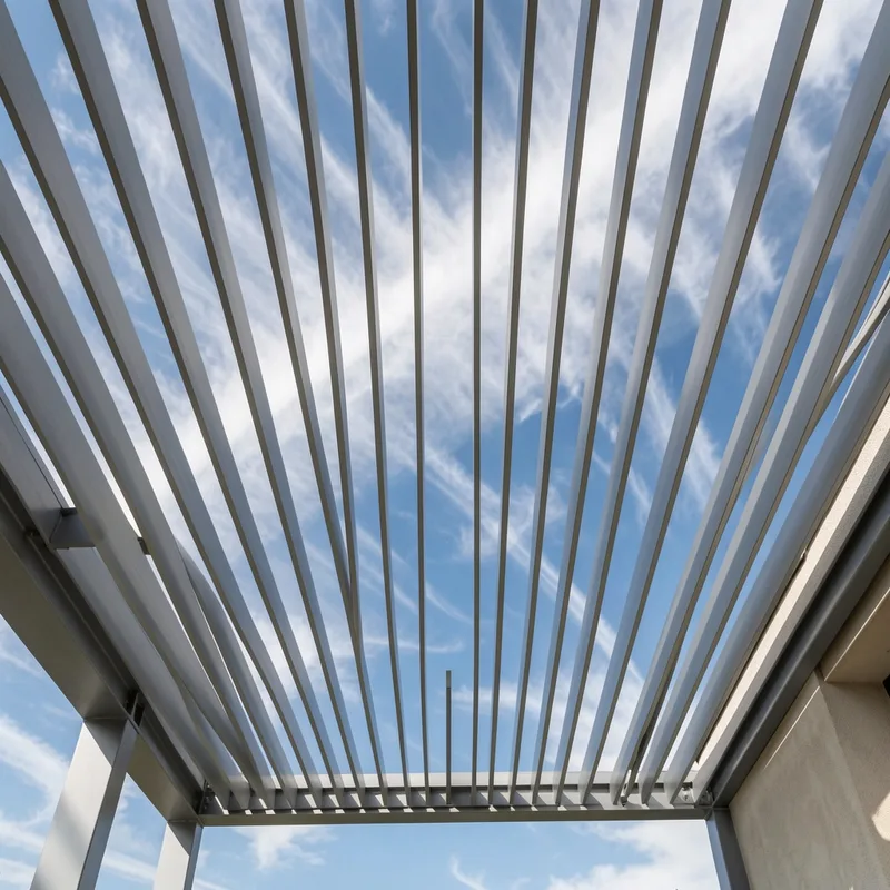 Lames orientables d&rsquo;une pergola bioclimatique en position ouverte sous un ciel venteux